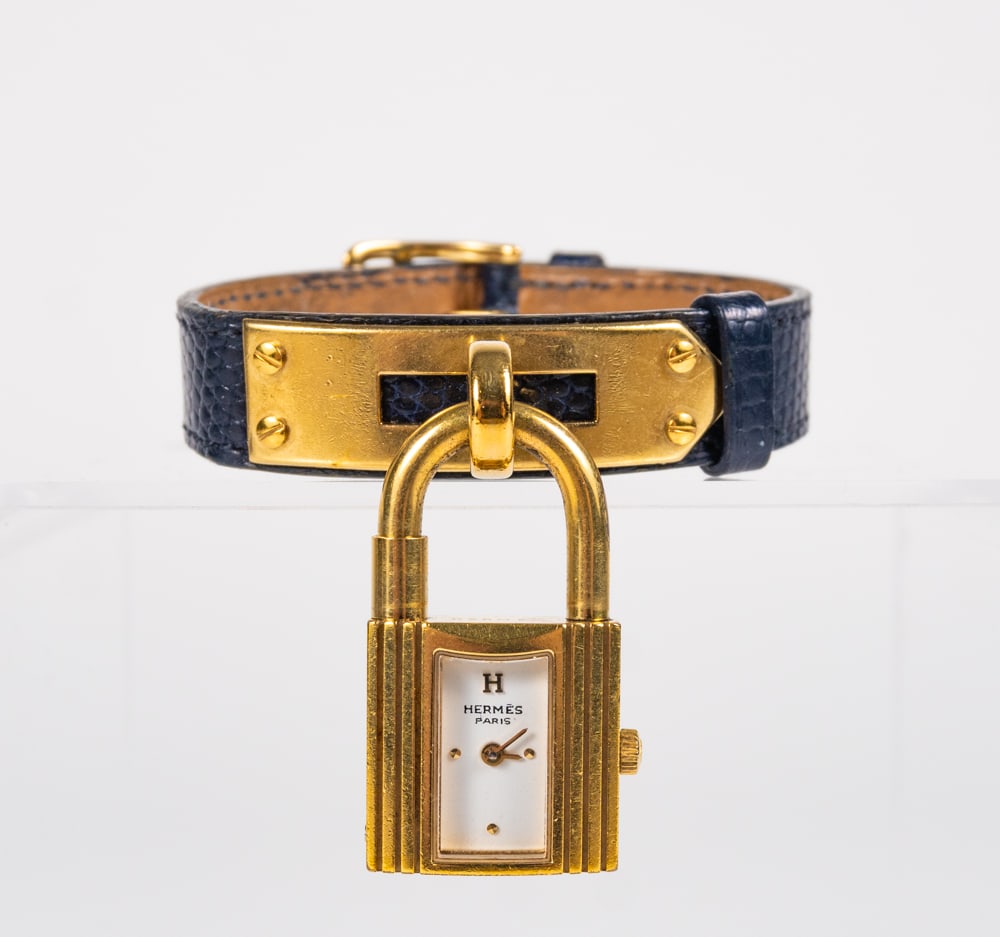 Hermes - Montre-bracelet en cuir Kelly plaqué or Hermes bleu Epsom: Hermes Montre-bracelet en cuir Kelly plaqué or Hermes bleu Epsom Description (FR): Montre-bracelet en cuir Kelly plaqué or Hermes bleu Epsom. Pièce vintage. Bracelet ajustable en cuir epsom bleu ma