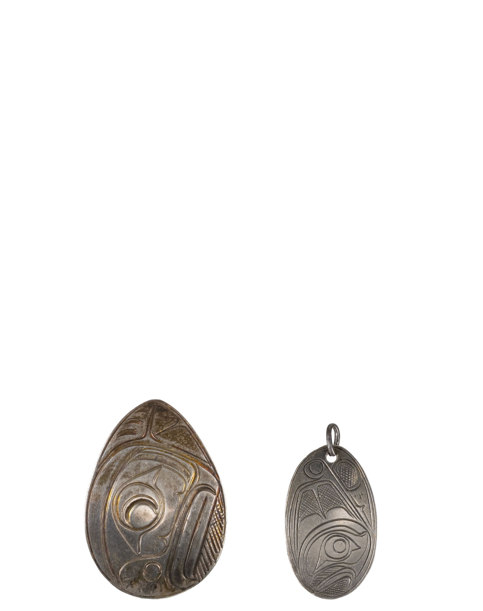 Set of 2 Haida North West Coast Sterling Silver Eagle Pendant: Ensemble de 2 pendentifs aigle en argent sterling de la côte nord-ouest Haïda Ensemble de 2 pendentif Haida representant l'aigle, tous deux signée et datée, 1. PAS 80, 2. DAWSON