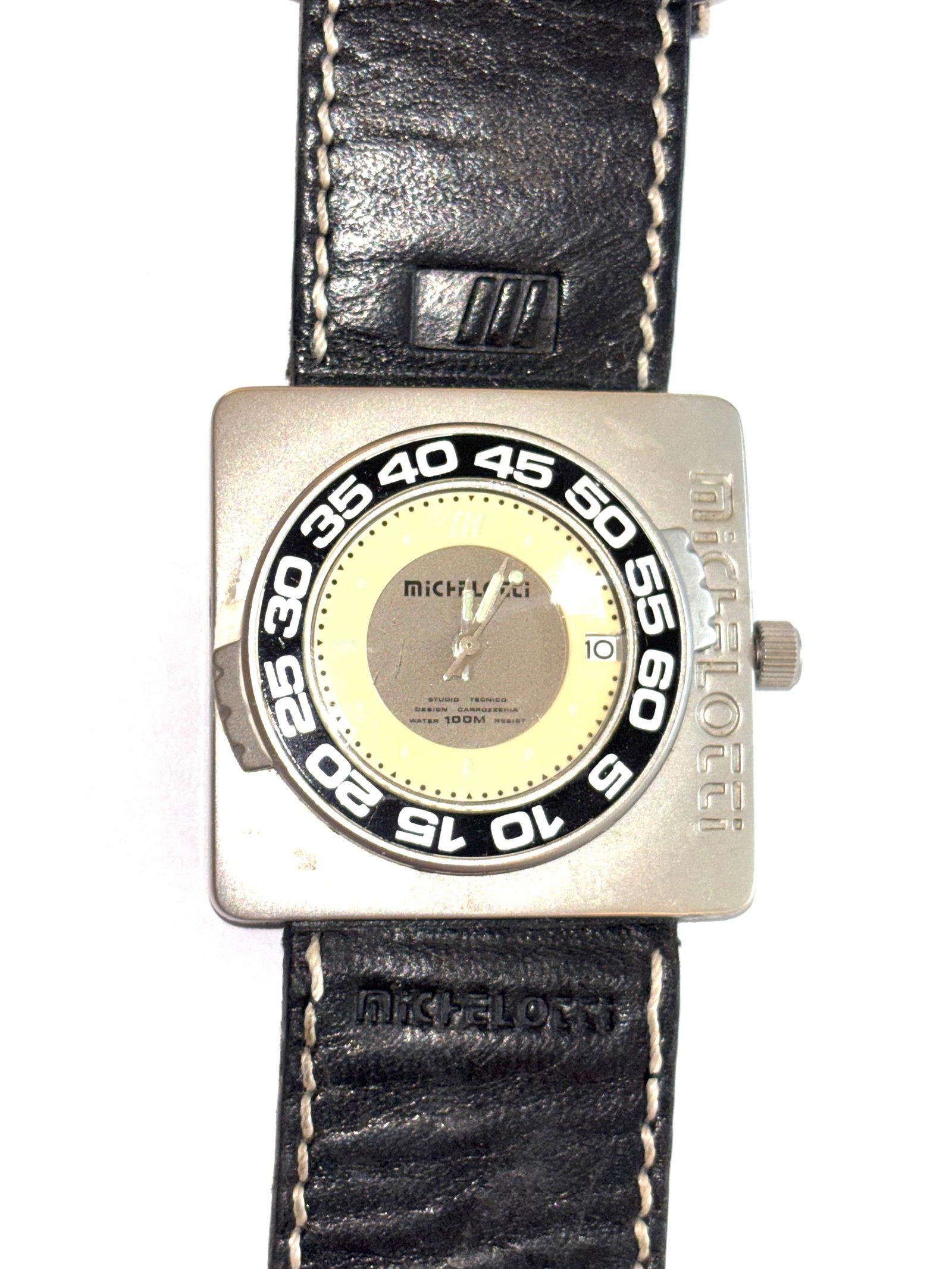 Montre Michellotti: Montre Carrozzeria Michelotti avec un boîtier carré en acier inoxydable et un bracelet en cuir noir. Elle présente un design unique inspiré des compteurs automobiles, avec une