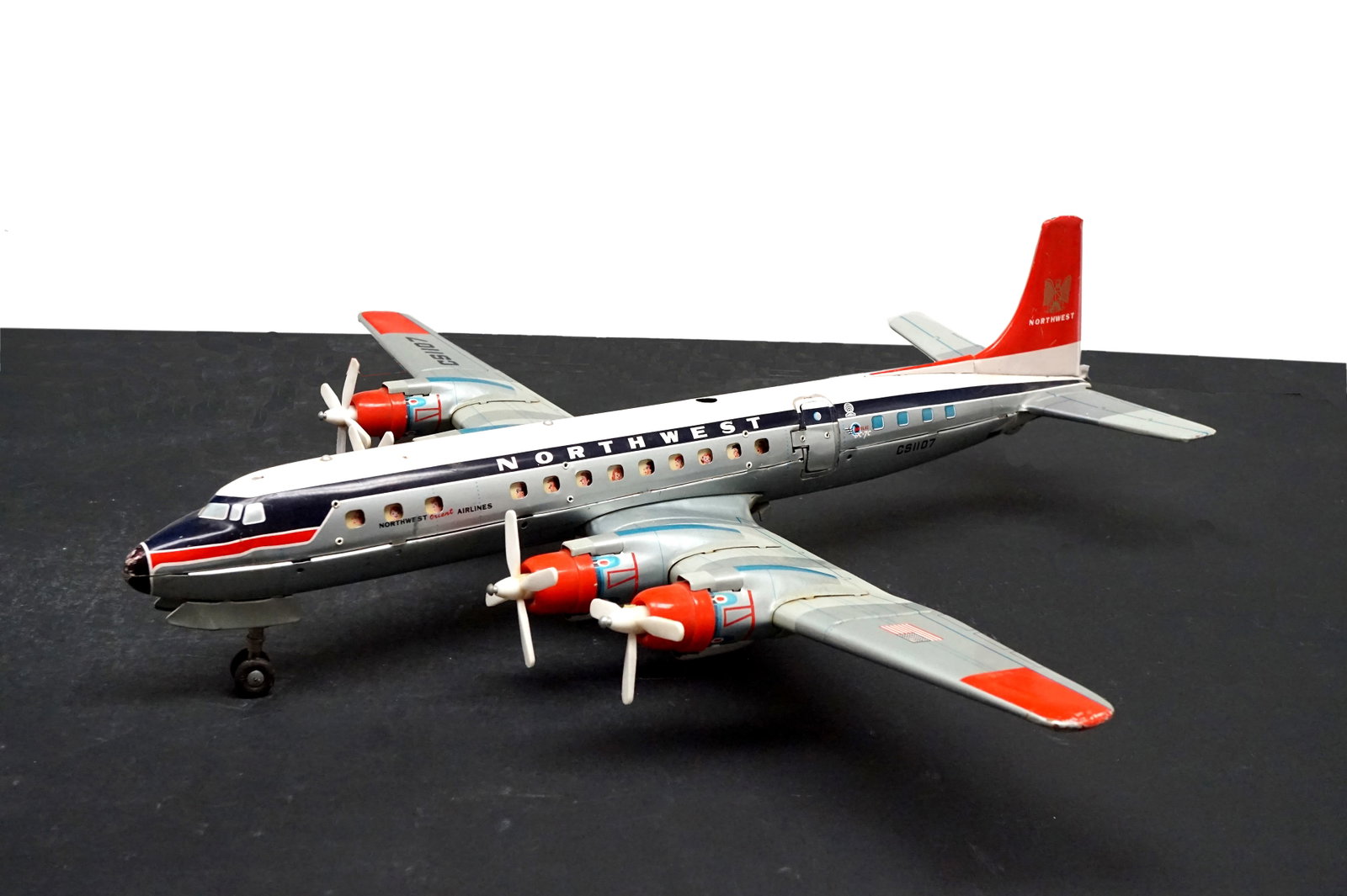 Antique airplane toy: Avion jouet antique fait au japon, compagnie Northwest Orient airline. Appareil Douglas DC-7, jouet a piles non-testé. Mesure:2large x 21 long pouces Rapport de condition: manque une pale sur