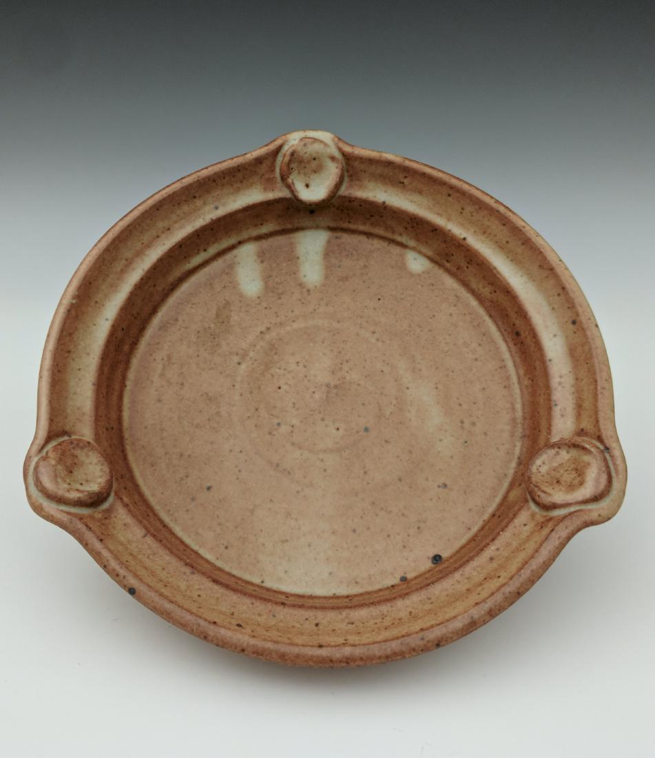 Warren MacKenzie - Footed plate: Lot 121 Warren MacKenzie - Footed plate American (1924-2018) Footed plate stoneware with shino glaze MacKenzie stamp on foot 1 3/4 x 7 inches Provenance: from the Collection of Arthur & Lillian Weiss,