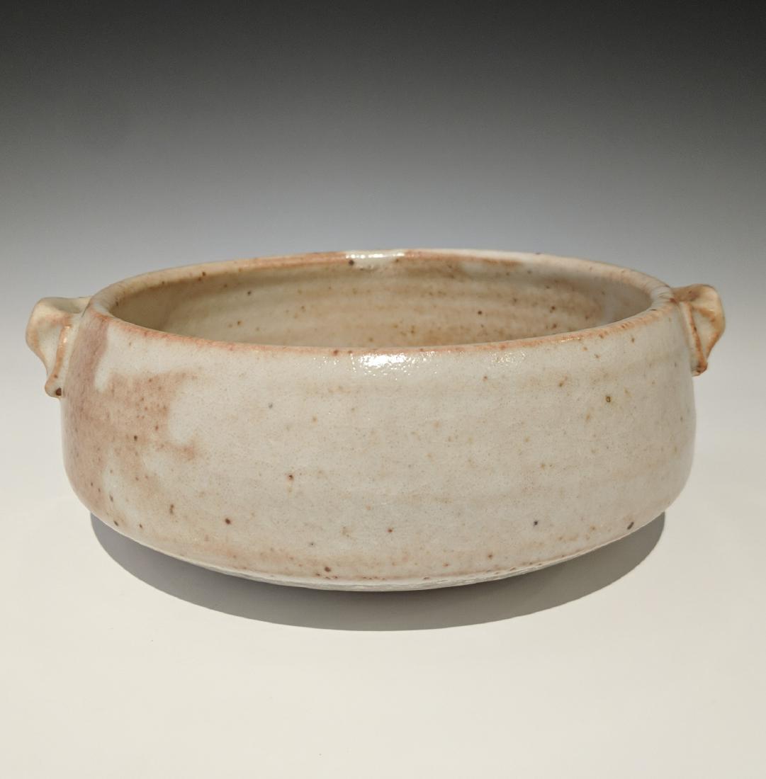 Warren MacKenzie - Shallow dish with two handles: Lot 130 Warren MacKenzie - Shallow dish with two handles American (1924-2018) Shallow dish with two handles stoneware with thick shino glaze MacKenzie stamp on foot 2 1/2 X 7 1/2 inches Provenance: fr