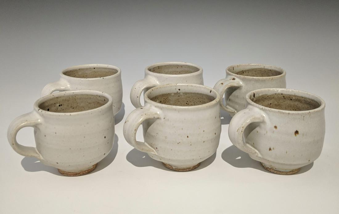 Warren MacKenzie - Six mugs: Lot 132 Warren MacKenzie - Six mugs American (1924-2018) Six mugs stoneware with white glaze MacKenzie stamps under handles 3 1/2 x 4 1/2 inches each Provenance: from the Collection of Arthur & Lill