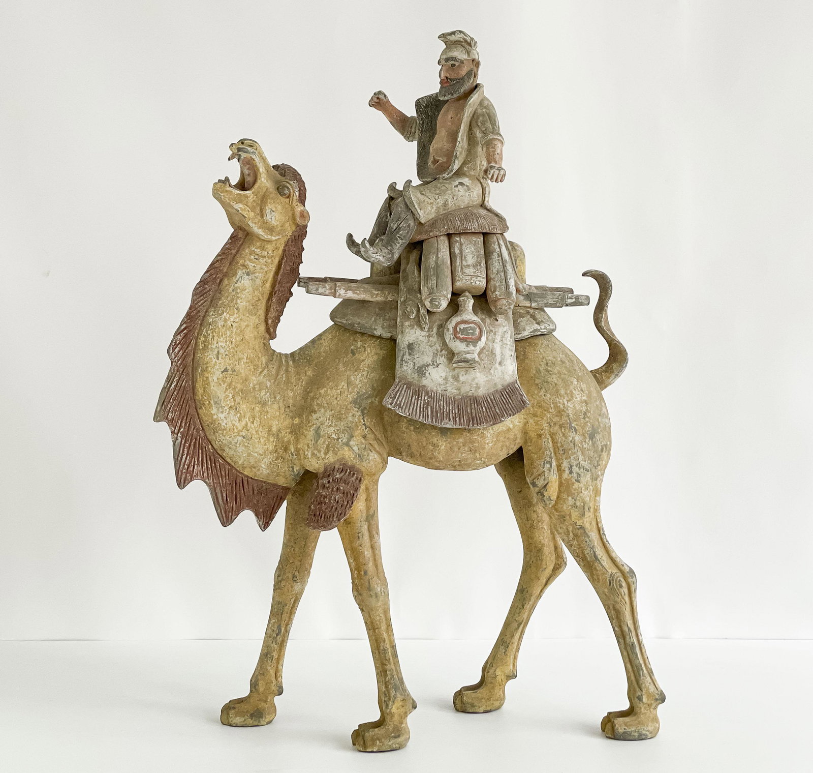 Chinese Painted Pottery Figure of a Camel and Rider: Lot 236 Chinese Painted Pottery Figure of a Camel and Rider (Tang Dynasty) the Bactrian camel is painted in buff ocher and red pigments, depicted with raised head and open mouth as if braying, and la
