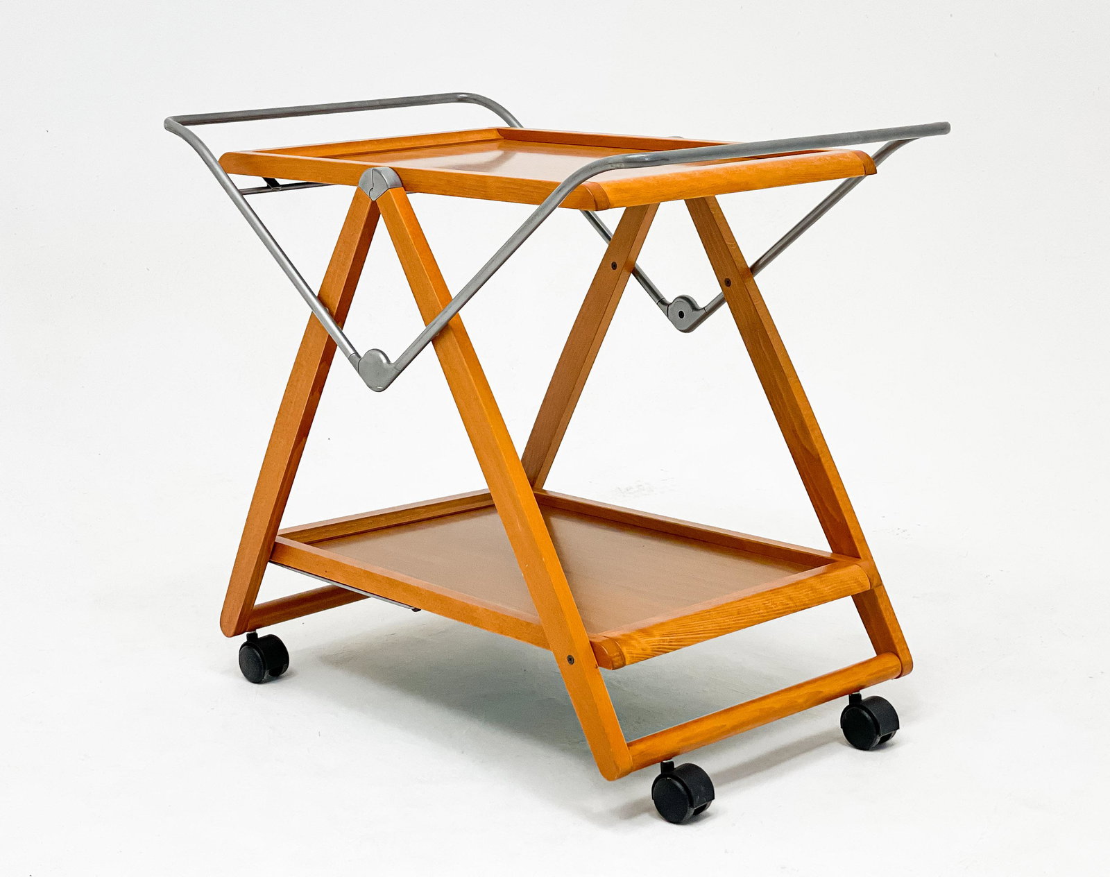 Modern Mixed Wood Bar Cart: Lot 24 Modern Mixed Wood Bar Cart two tiers with tubular handles and raised on casters, collapses for storage 28 3/4 x 34 1/4 x 20 1/4 inches