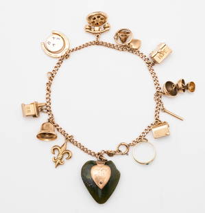 14K Yellow Gold Charm Bracelet: Lot 32 14K Yellow Gold Charm Bracelet chain clasp marked ”14K” nine charms marked ”14K” and one charm marked ”10k” including one charm with carved jade heart appro