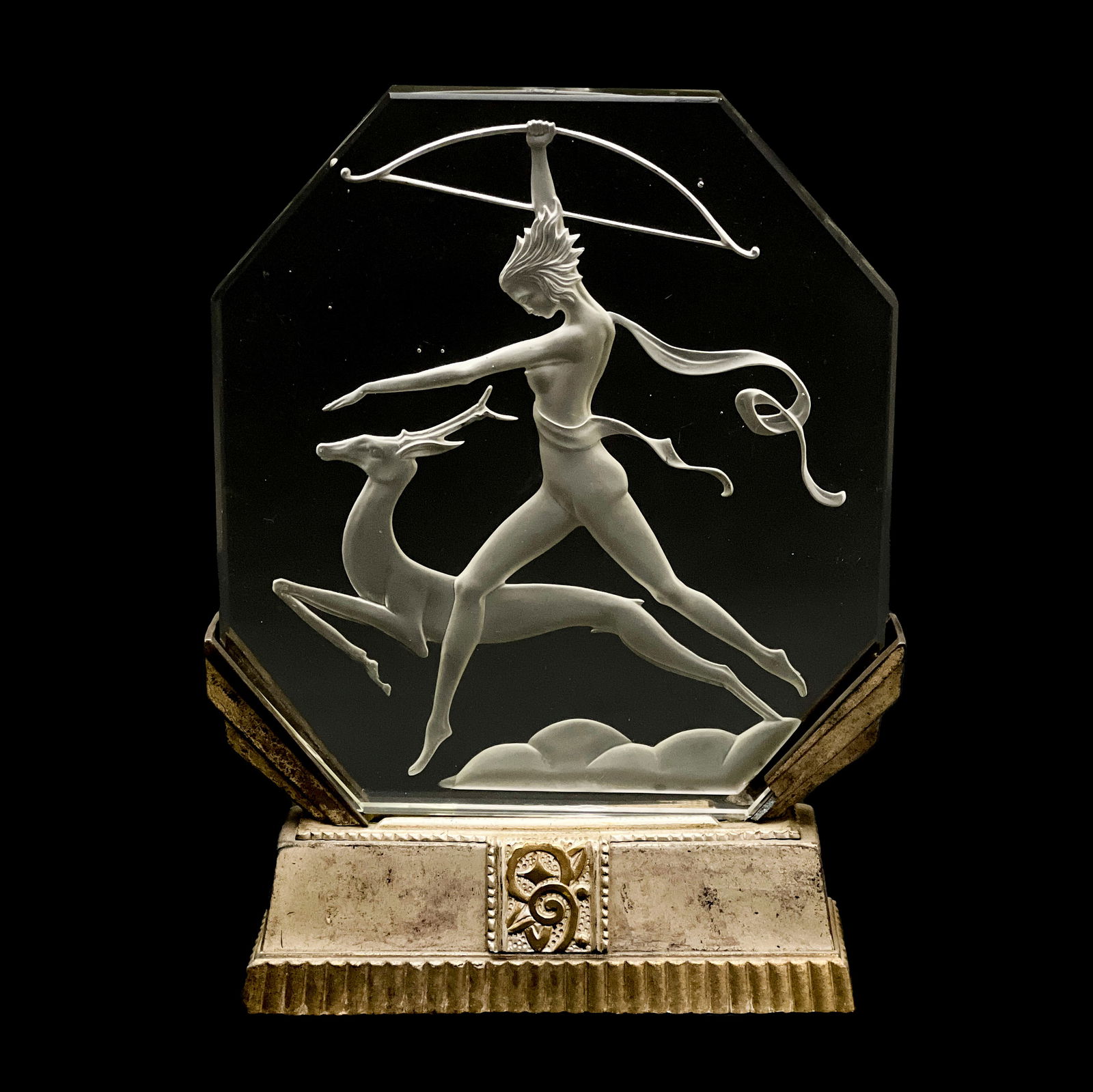 Art Deco Illuminated Glass Panel Depicting Diana: Lot 195 Art Deco Illuminated Glass Panel Depicting Diana octagonal glass plaque with beveled edges and intaglio decoration of an archer and deer fitted into cast silver-colored metal base, with a hor
