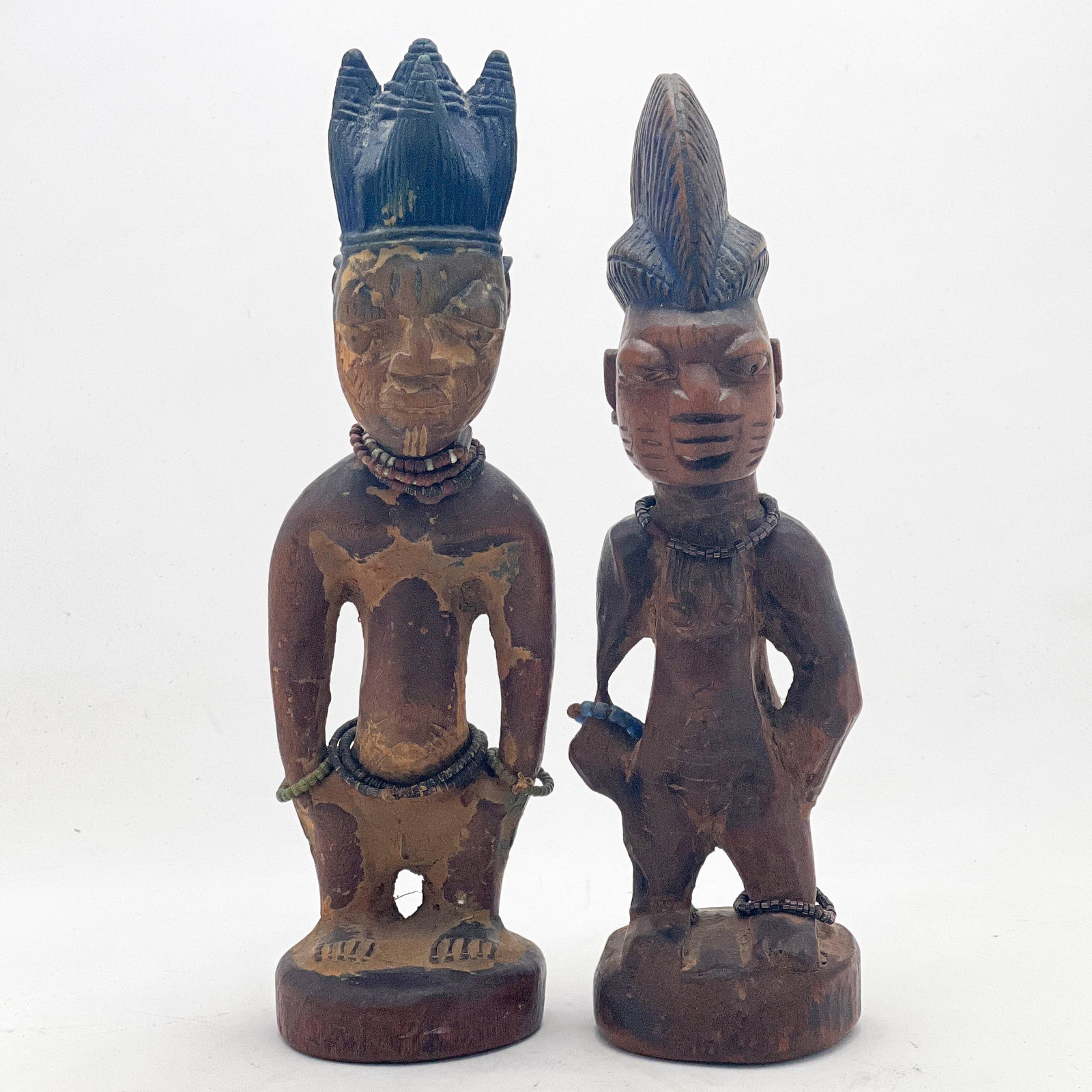 African - Male and Female Yoruba Ibeji Figures, Pair: Lot 27 African Male and Female Yoruba Ibeji Figures, Pair wood, beads Male and female figures, each nude with tattooed cheeks / scarification marks, with beaded jewelry and traces of indigo blue pigme