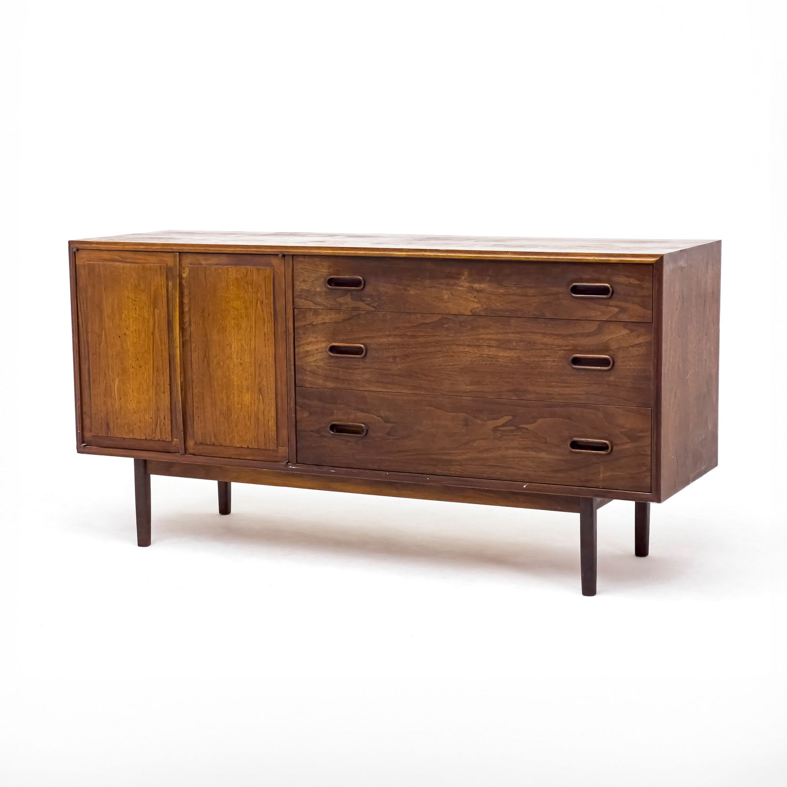 Jack Cartwright - Credenza: Lot 30 Jack Cartwright American (XX) Credenza walnut, teak credenza with two-doors and three drawers for Founders, USA 30 x 60 x 18 inches Provenance: The Estate of Robert A. Blake