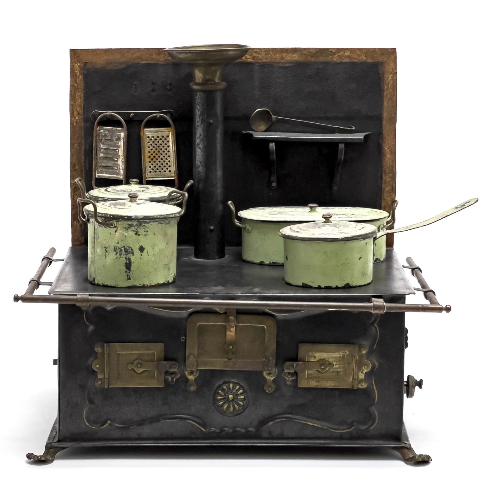 Märklin Toy Stove with Accessories: Lot 164 Märklin Toy Stove with Accessories Three door oven, formed steel tin, four burners, size with, with four cooking pots, along with two graters and a ladle 11 1/4 x 12 1/2 x 9 inches Prove