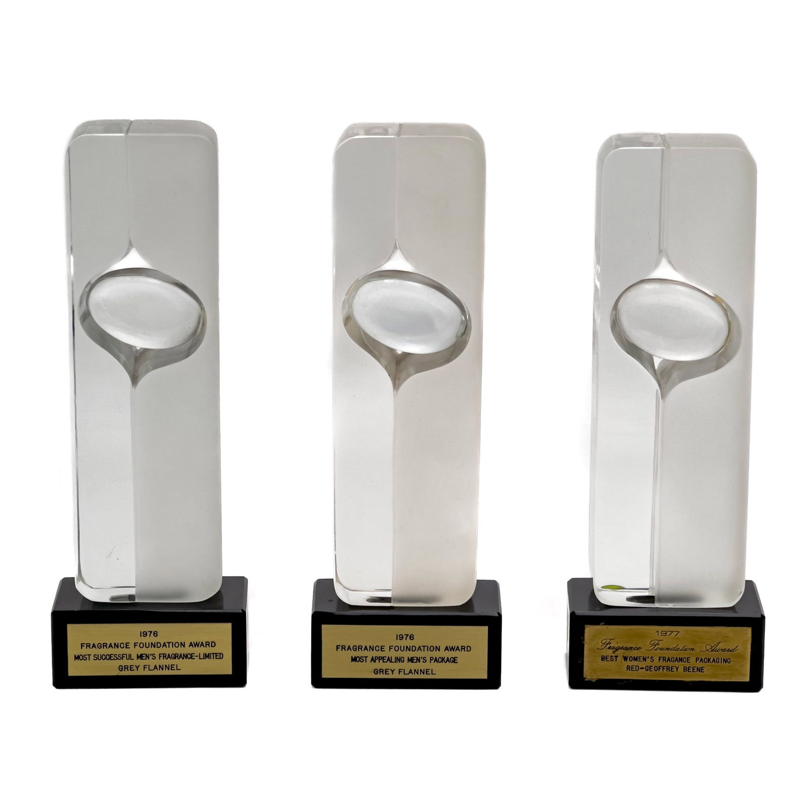 Pierre Dinand - Trophies for Geoffrey Beene, Group of 3: Lot 317 Pierre Dinand French (b. 1931) Trophies for Geoffrey Beene, Group of 3 glass, lacquered wood Each a totem form form glass sculpture with lacquered base displaying plaque, produced by Cristal P