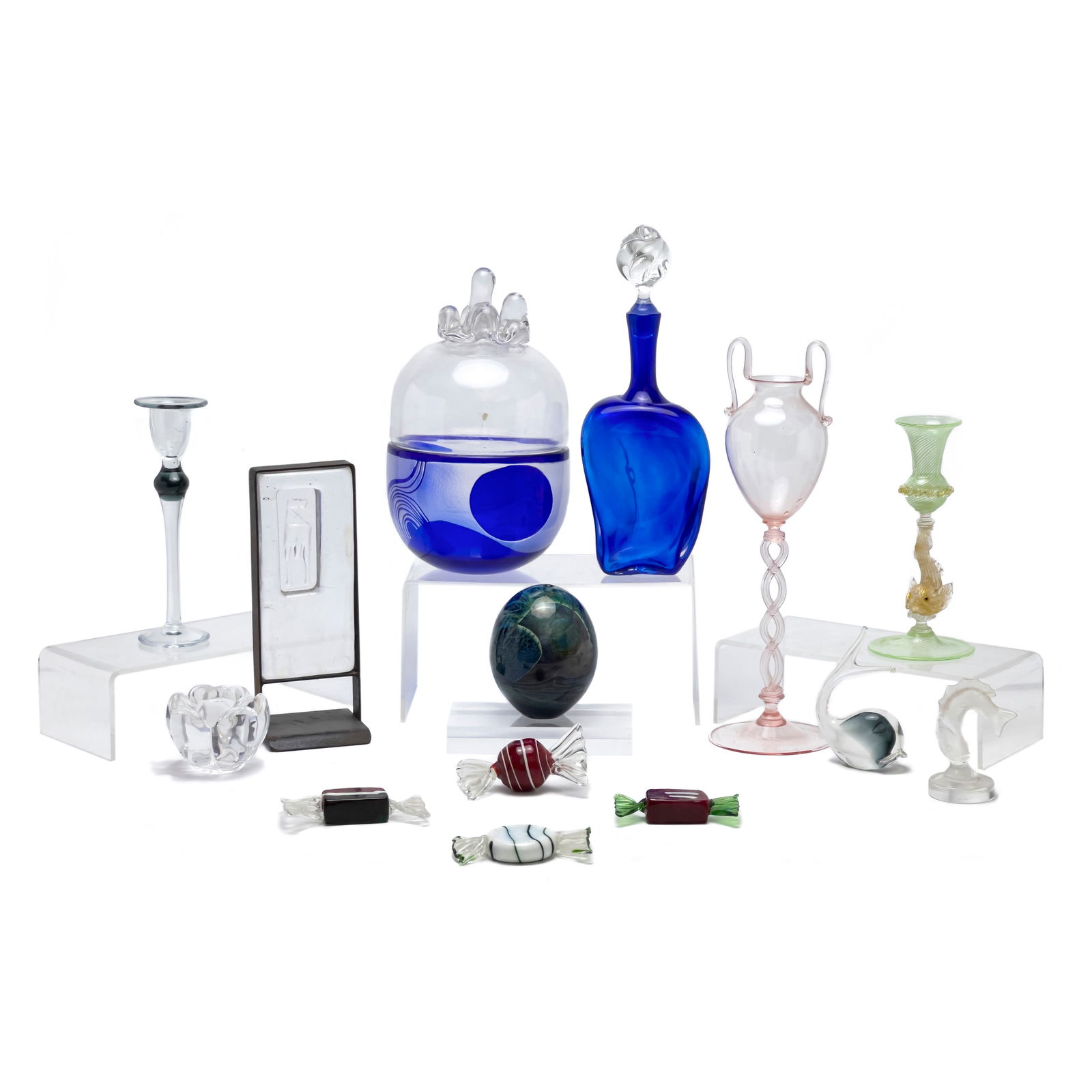 Lalique and Others - Art Glass, Group of 14: Lot 63 Lalique and Others - Art Glass, Group of 14 glass Comprising, Lalique fish, Pauly & C. Murano tall pink glass vessel, two different candle holders, blue bottle with stopper, large blue lidded