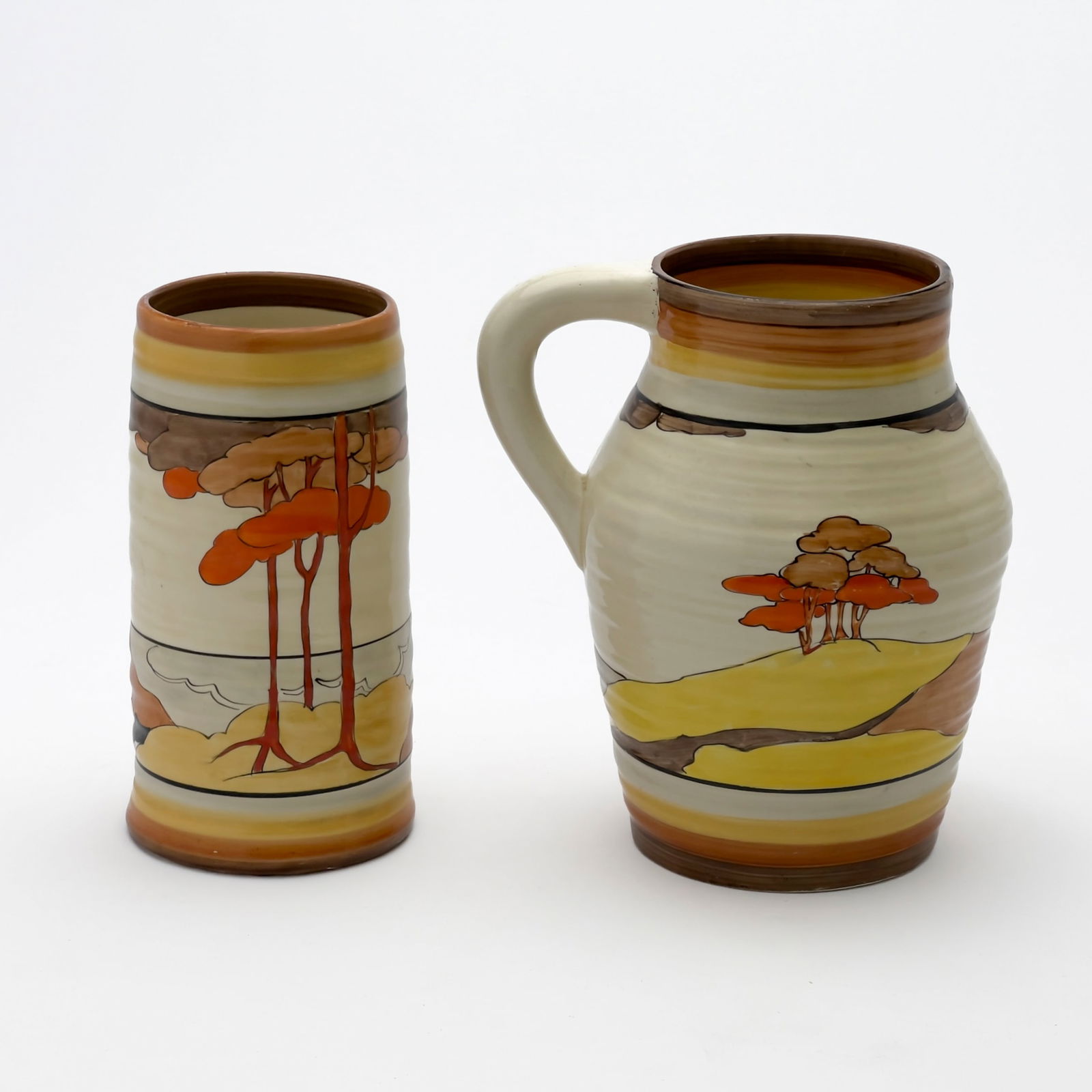 Clarice Cliff - Bizarre Lotus Jug and Vase in ”Coral Firs”: Lot 76 Clarice Cliff English (1899-1972) Bizarre Lotus Jug and Vase in ”Coral Firs” hand-painted ceramic manufacturer's mark to bottom of both jug: 7 x 6 inches Provenance: Property from a