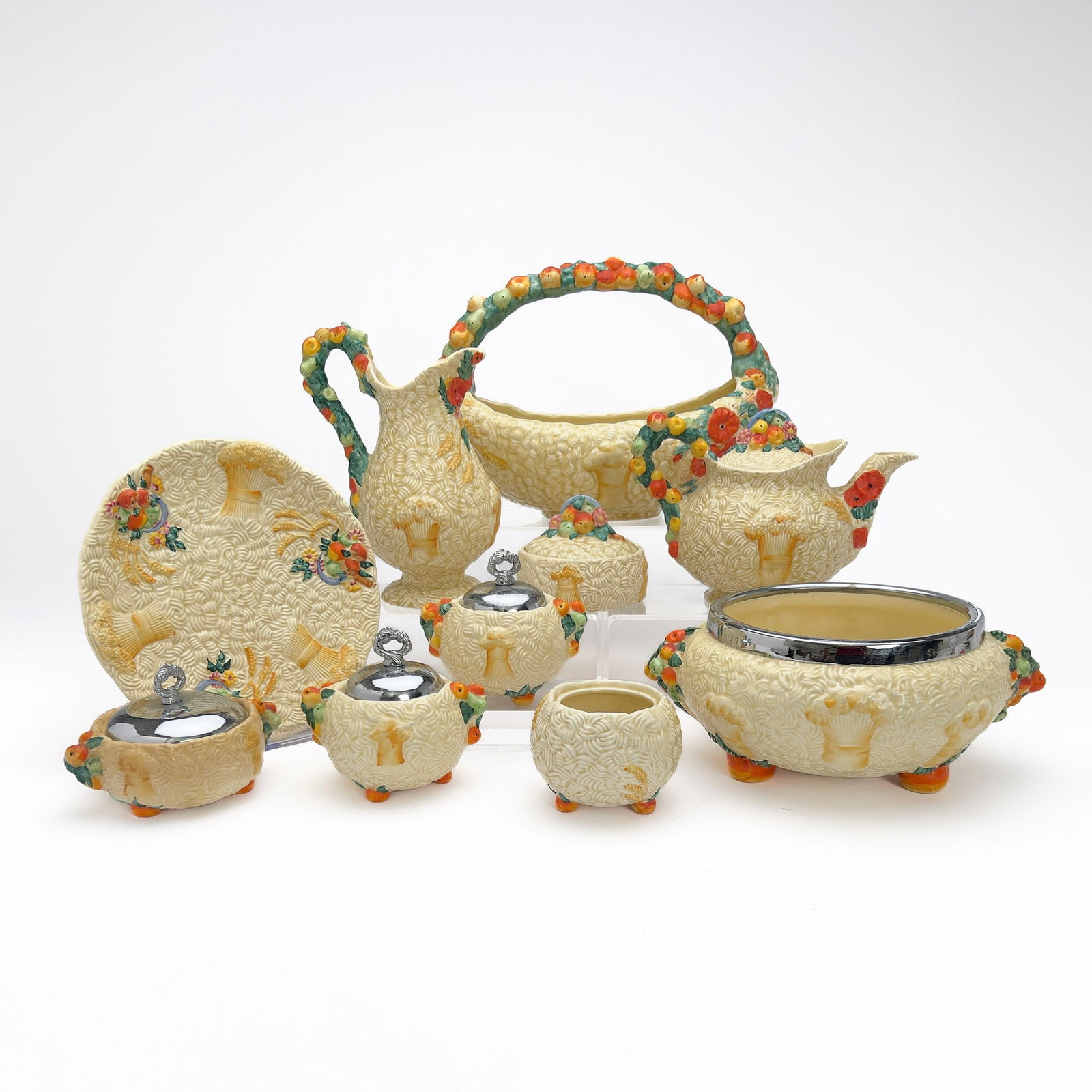 Clarice Cliff - Collection of Ceramic Serving Dishes in ”Celtic Harvest,” Group of 10: Lot 85 Clarice Cliff English (1899-1972) Collection of Ceramic Serving Dishes in ”Celtic Harvest,” Group of 10 hand-painted ceramic, metal Comprising of a teapot, a jug, a swing-handle bas