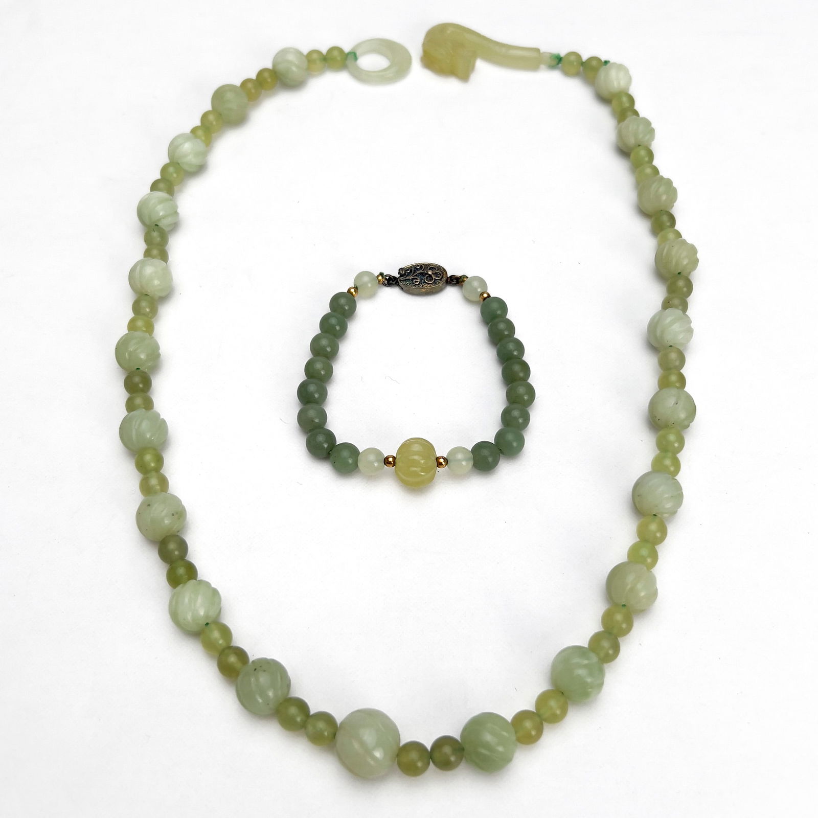 Jade Bracelet and Necklace: Lot 51 Jade Bracelet and Necklace jade A two tone jade necklace and bracelet, bracelet with clasp stamped ”Silver”, necklace with a carved jade clasp. length (longest): 24 1/4 inches
