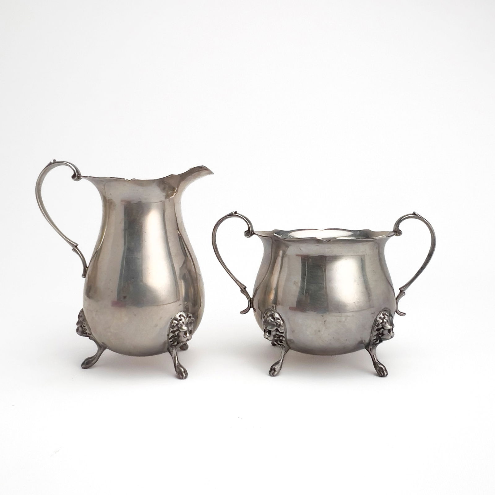 Silver Sugar and Creamer: Lot 138 Silver Sugar and Creamer sterling silver Sterling silver group, comprising of one sterling sugar bowl and one cream jug with matching lion head decorations to feet total approximate weight: