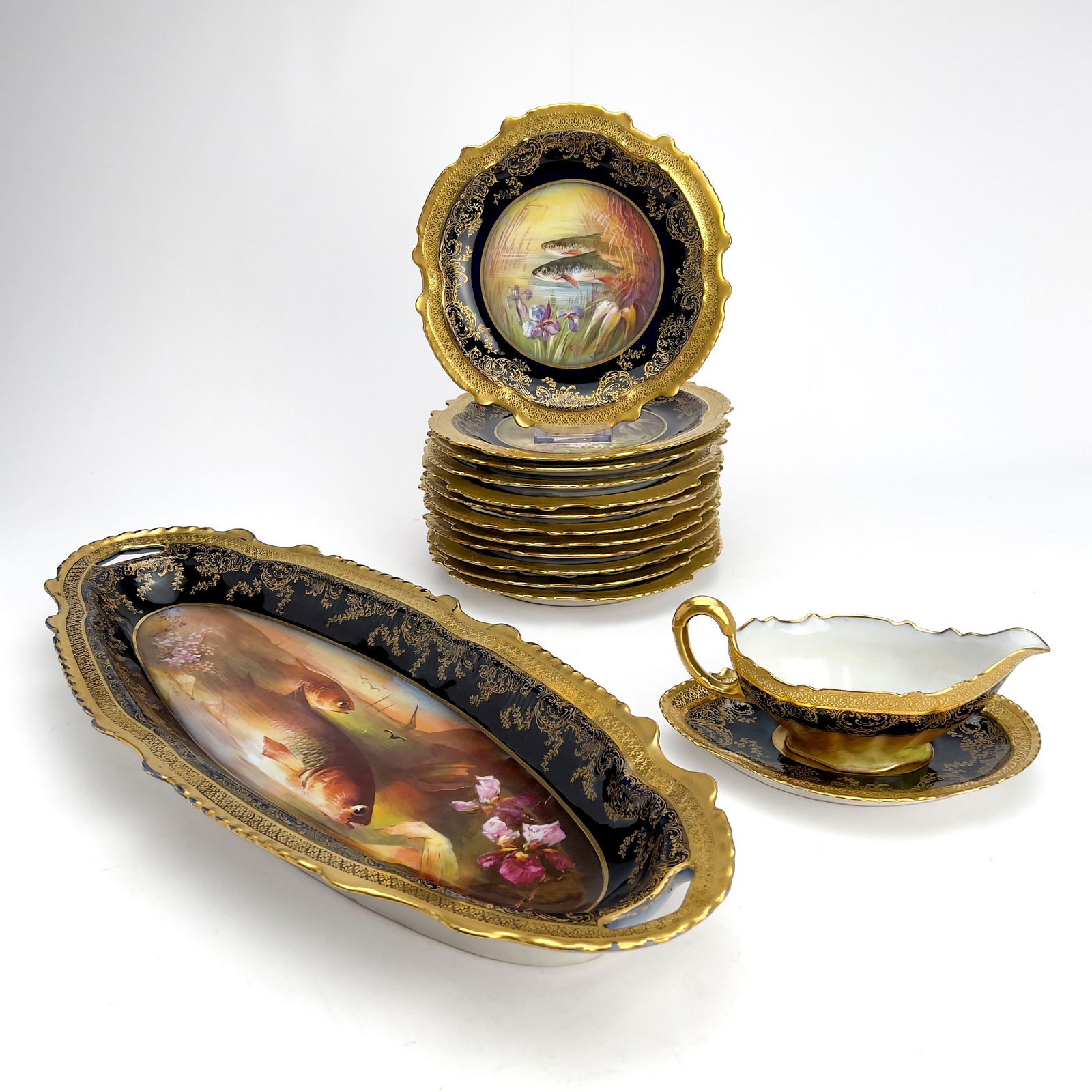 Limoges Ornate Porcelain Fish Service, Set of 15: Lot 214 Limoges Ornate Porcelain Fish Service, Set of 15 porcelain Comprising one large platter with a scalloped oval form, a sauce boat with an underplate, and twelve dinner plates. All decorated wi