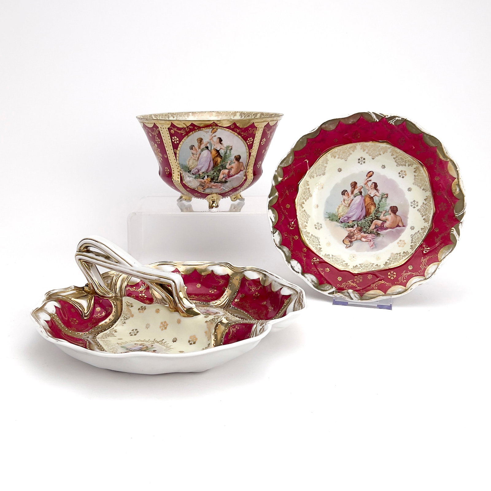 Royal Vienna Three-Piece Serving Set: Lot 221 Royal Vienna Three-Piece Serving Set porcelain Viennese porcelain group, comprising of decorative porcelain handled serving dish, footed bowl, and plate in cranberry with gold accents