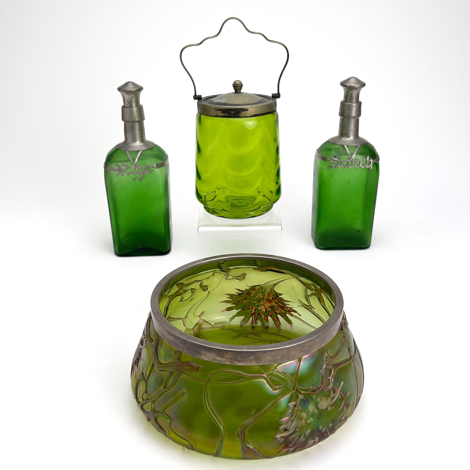 Collection of Green Glass Vessels: Lot 230 Collection of Green Glass Vessels glass Green glass group, comprising two matching green glass pewter mounted decanters (1 Rye, 1 Scotch), a green glass biscuit barrel with silver plated