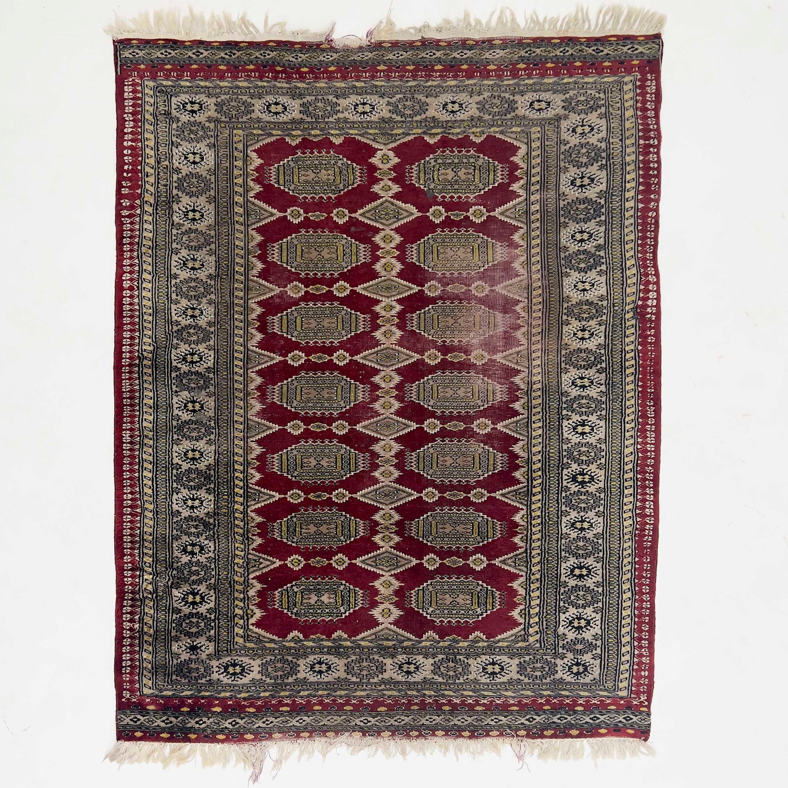 A Pakistani Bokhara Wool Rug: Lot 193 A Pakistani Bokhara Wool Rug Wool, cotton Description: A late 20th-century Pakistani Bokhara hand-woven wool rug featuring two columns of seven octagonal gül medallions on a ruby red fiel