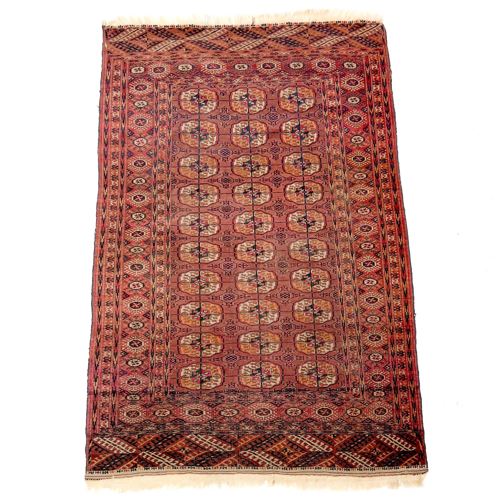 Antique Turkman Tekke Rug: Lot 195 Antique Turkman Tekke Rug (19th/20th Century) wool Description: An antique Tekke Turkmen rug of rectangular form featuring a rich madder-red field decorated with four vertical columns of tradi
