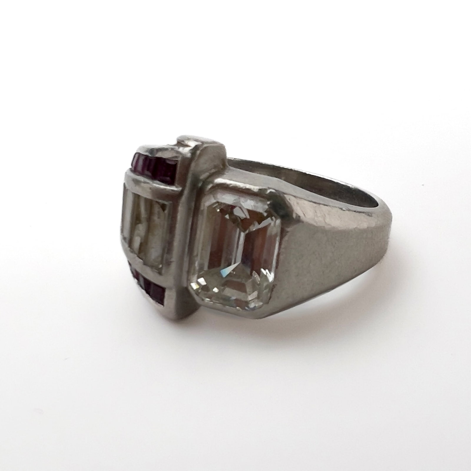 An Art Deco diamond, ruby, and platinum cocktail ring: Lot 91 An Art Deco diamond, ruby, and platinum cocktail ring (circa 1935) Platinum, diamond, ruby sta,ped Description: An emerald-cut diamond weighing an estimated 1.8 carats and measuring approximate