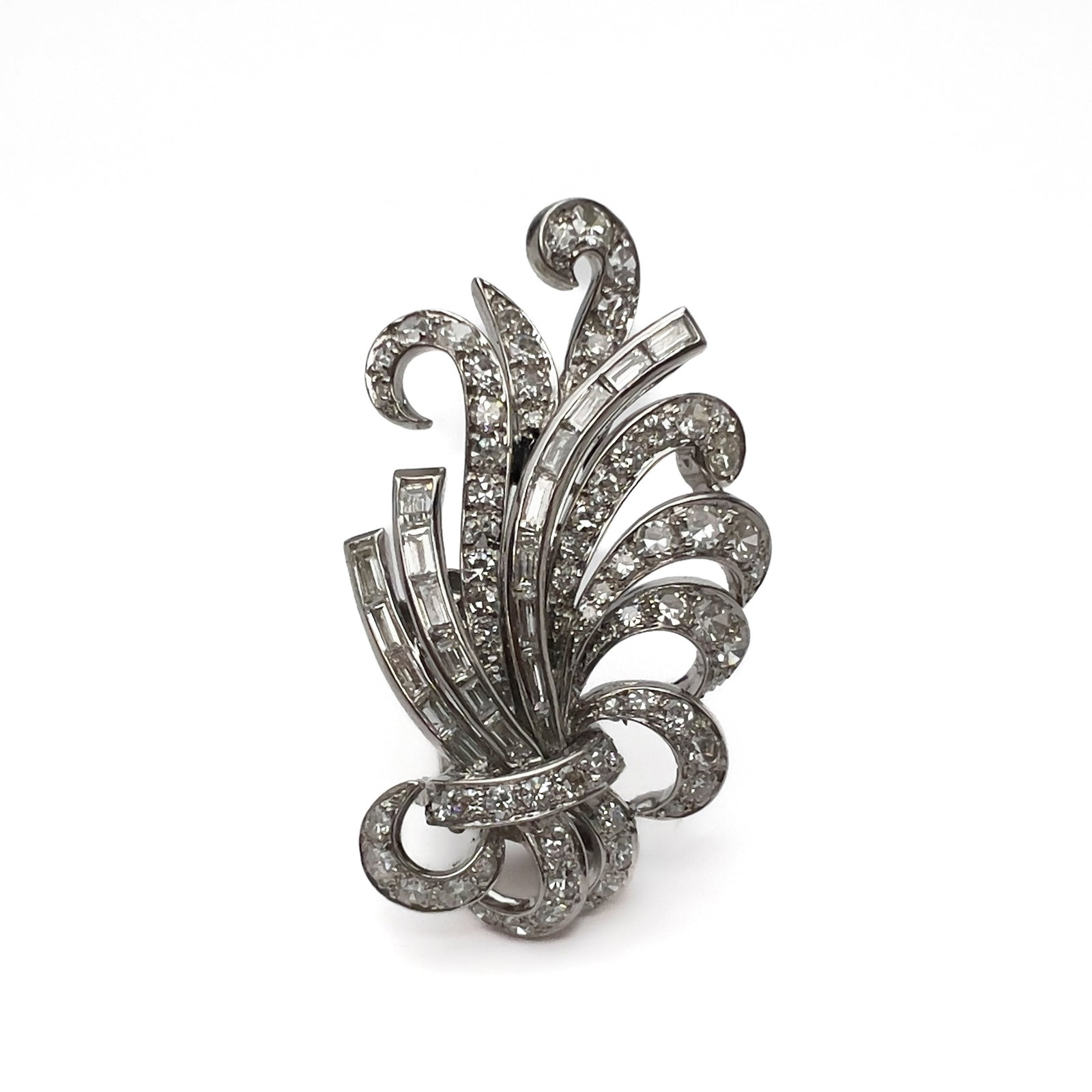 A mid-century platinum and diamond spray brooch: Lot 92 A mid-century platinum and diamond spray brooch (mid-20th century) Platinum, diamond Description: A platinum spray brooch weighing approximately 12.8 grams, featuring an abstract, fanned leaf-a
