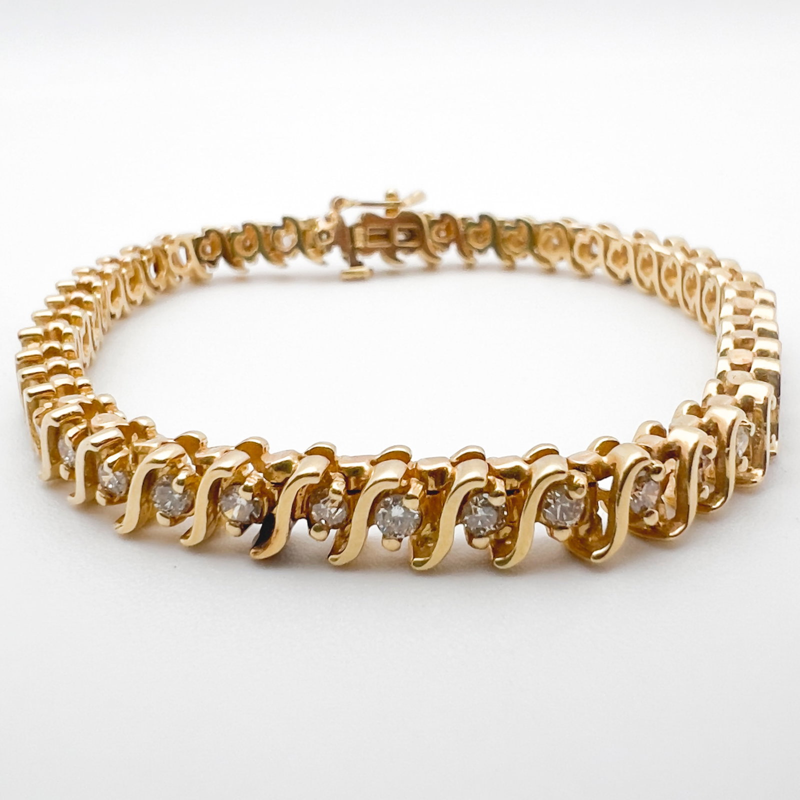 Yellow Gold and Diamond S Link Tennis Bracelet: Lot 98 Yellow Gold and Diamond S Link Tennis Bracelet 14k gold, diamonds length: 7 inches stamped Description: 14k gold S link tennis bracelet, set with 44 round diamonds (approximately 2.5 mm each an