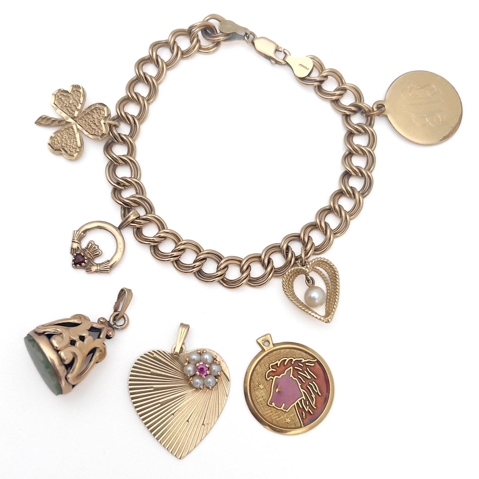 Charm Bracelet with 2 Gold Charms: Lot 100 Charm Bracelet with 2 Gold Charms 14 and 18k gold, and gold fill stamped Description: An 8 inch gold filled charm bracelet with 5 gold plated charms and two detached gold charms; 18k gold enam