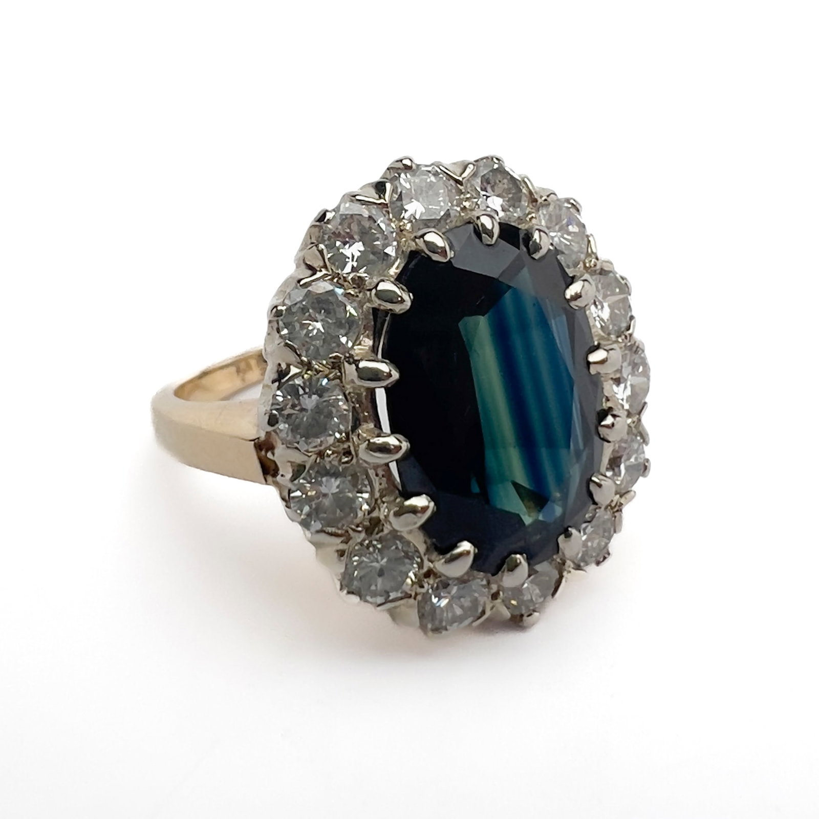 Natural Sapphire and Diamond Halo Gold Ring: Lot 113 Natural Sapphire and Diamond Halo Gold Ring 14k yellow gold, natural sapphire, diamond stamped Description: A vintage cast 14-karat yellow gold cocktail ring in size 6 centered by a prominent