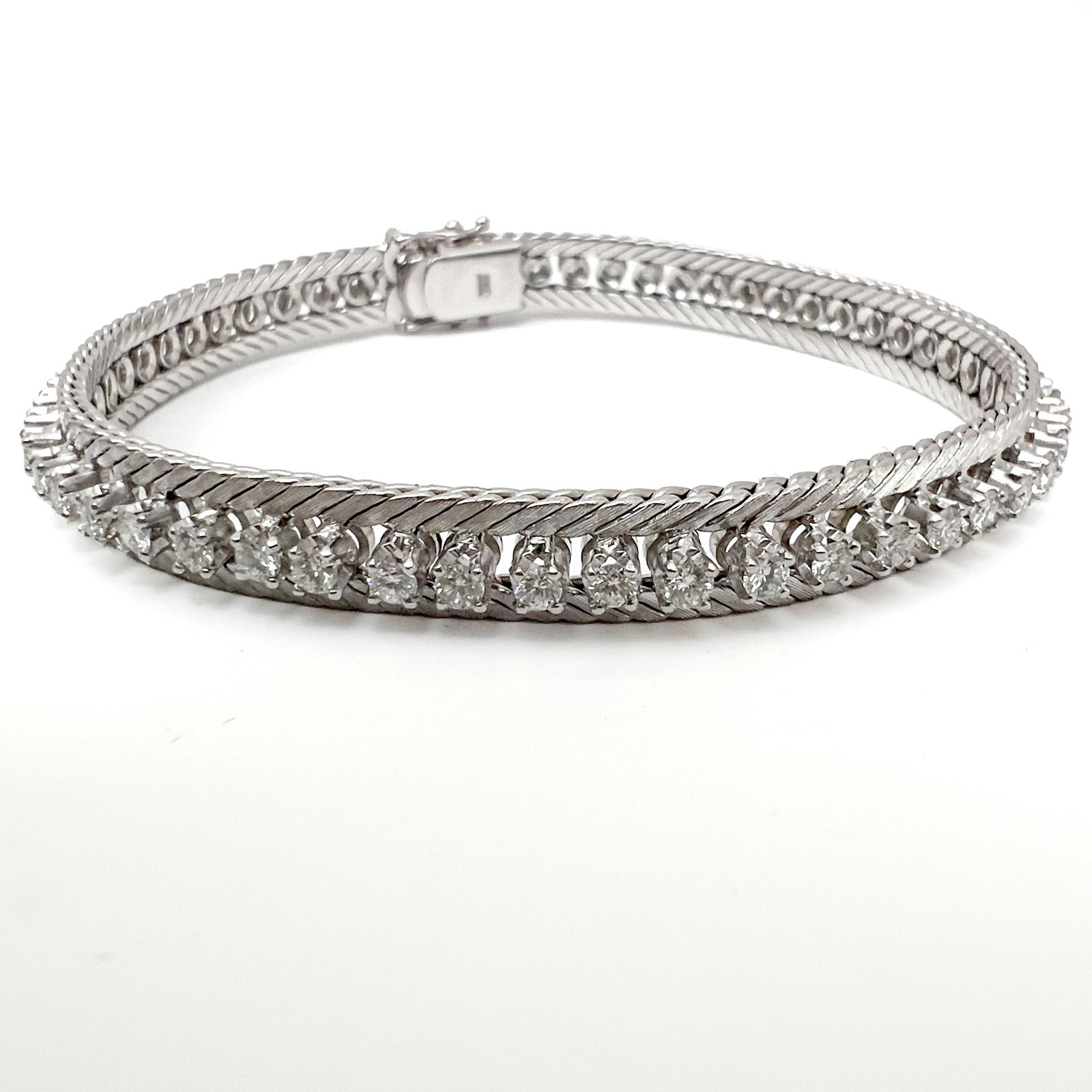 An 18-Karat White Gold and Diamond Tennis Bracelet: Lot 121 An 18-Karat White Gold and Diamond Tennis Bracelet (20th Century) 18k white gold, diamond length: 7 1/4 inches stamped Description: An 18-karat white gold tennis-style bracelet weighing approx