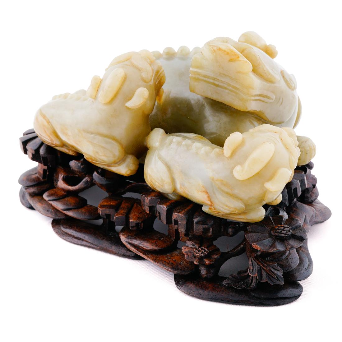 JADE SCULPTURE OF THREE QILIN ON STAND: Chinese jade carvings of three Qilin on carved display stands. All resting together in a relaxed and tranquil look. Large semi ferocious faces with single horns erecting from their heads. Sharp spine-