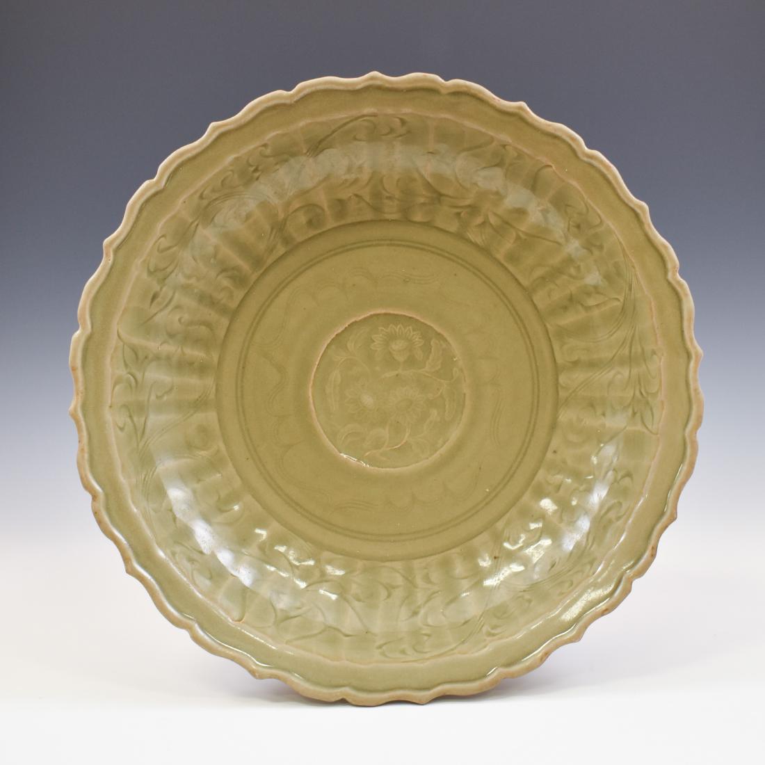 MING LONGQUAN CELADON BARBED RIM CHARGER: Chinese Ming Dynasty Long Quan celadon porcelain plate. Finely potted in shallow vessel form, slightly flared lip with a shallow draft, with broad wide central interior, rounded cavetto gently taperin