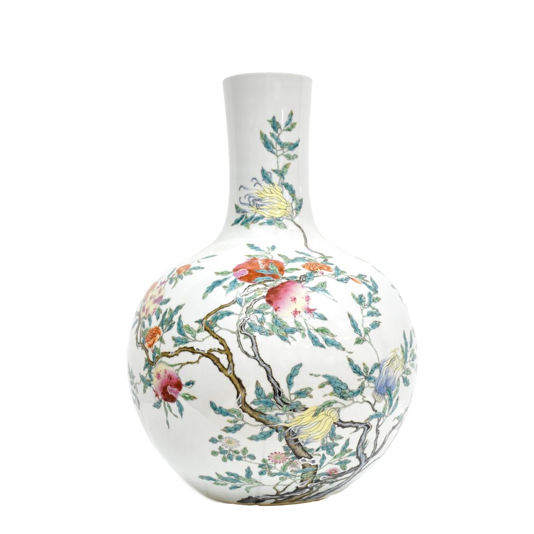 LARGE CHINESE FAMILLE ROSE POMEGRANATE CELESTIAL VASE: Chinese porcelain potted in a celestial form, bulbous body with round shoulder gently tapered toward tall cylindrical neck, leading to slightly wider rim; raised upon a flat concaved base. The exterio