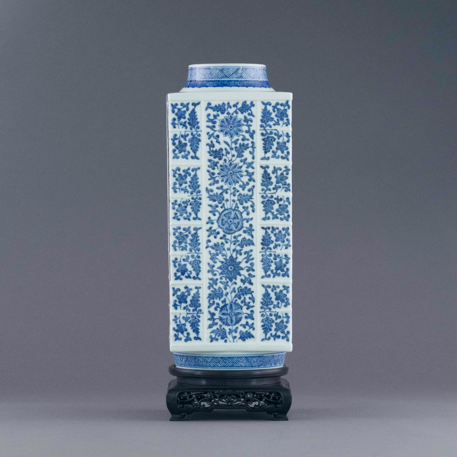 QIANLONG LUE & WHITE WRAPPEED FLORAL ZONG VASE: Chinese Qing Dynasty Period, Qianlong blue & white wrapped floral Zong vase. The Porcelain potted in Zong shape vase, thick and large body, squared body, with circle opening mouth and base, raised on 