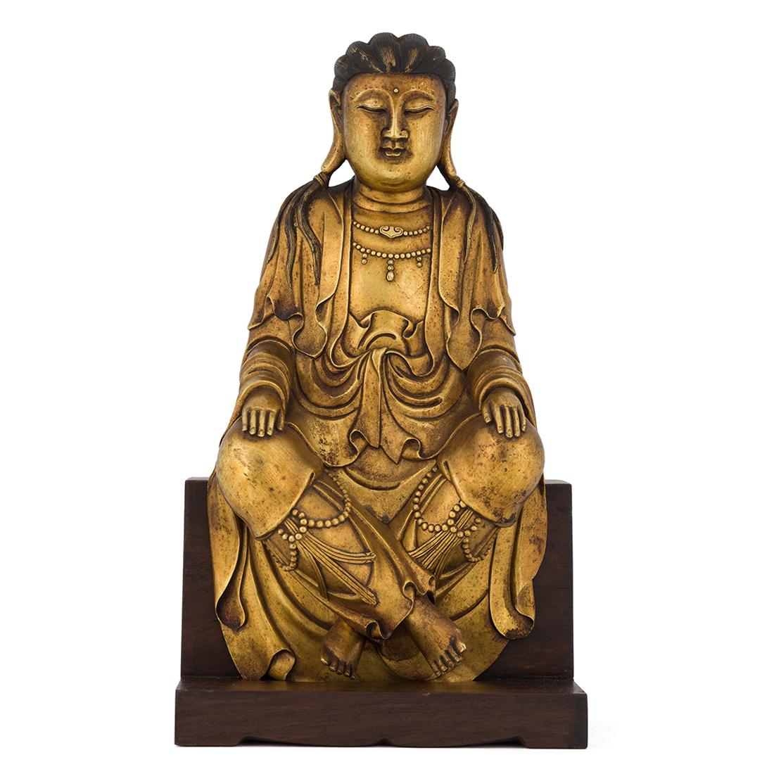 MING GILT BRONZE GAUTAMA BUDDHA ON WOODEN STAND: Measurements: 17.375in H x 7in W Chinese Tibetan Ming Dynasty gilt bronze Buddha figure of Gautama, the Prince (5th Century B.C.) is the royal prince who became the Buddha Shakyamuni and the founder o