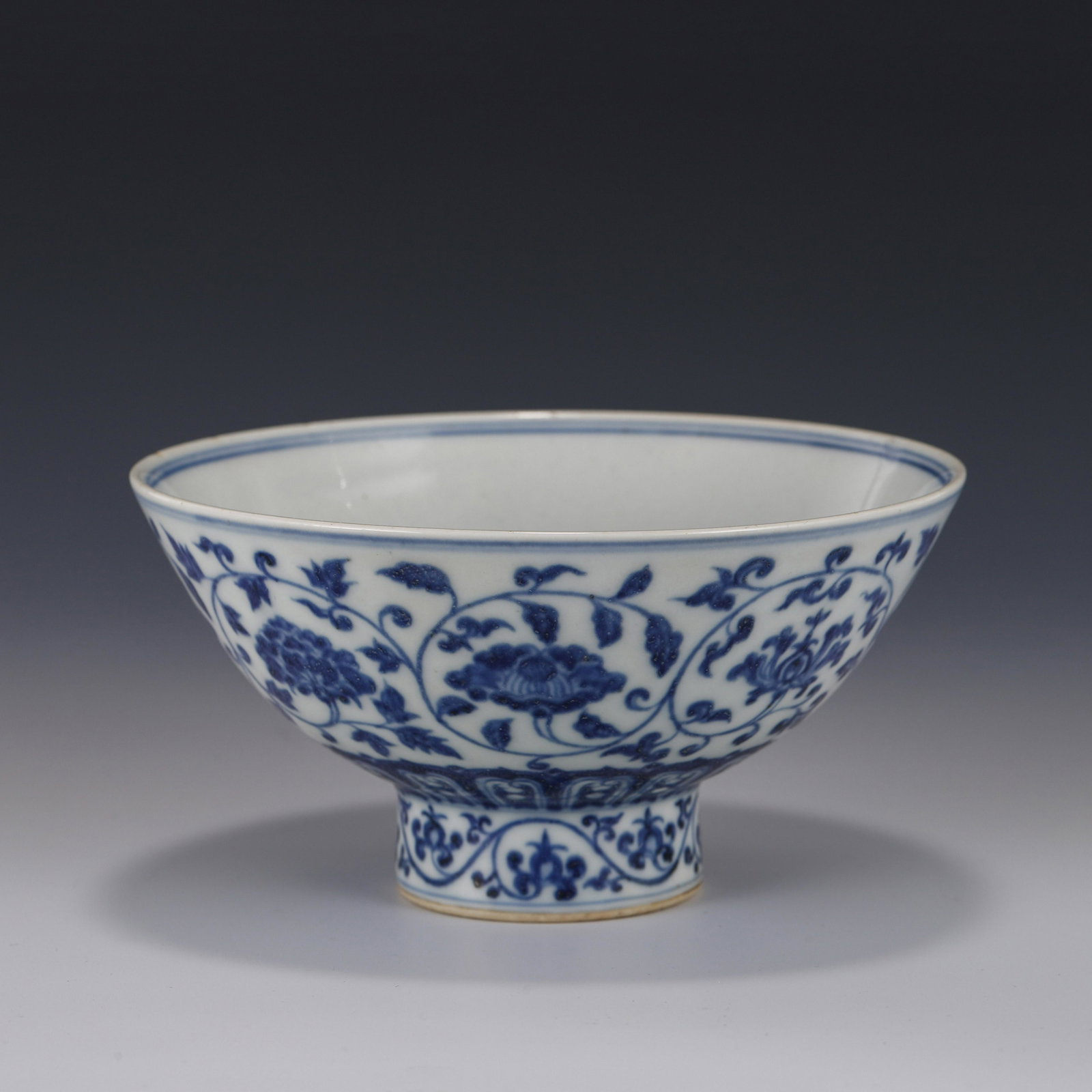 BLUE & WHITE SCROLLING FLORAL HIGH STEM BOWL: Measurements: Height: 7.5 cm Diam: 15.2 cm PROVENANCE: From the Estate of Ronald Gene Arnes (1926-2019) of Chattanooga, Tennessee. A private collector, US Navy World War II Veteran and served in Naval
