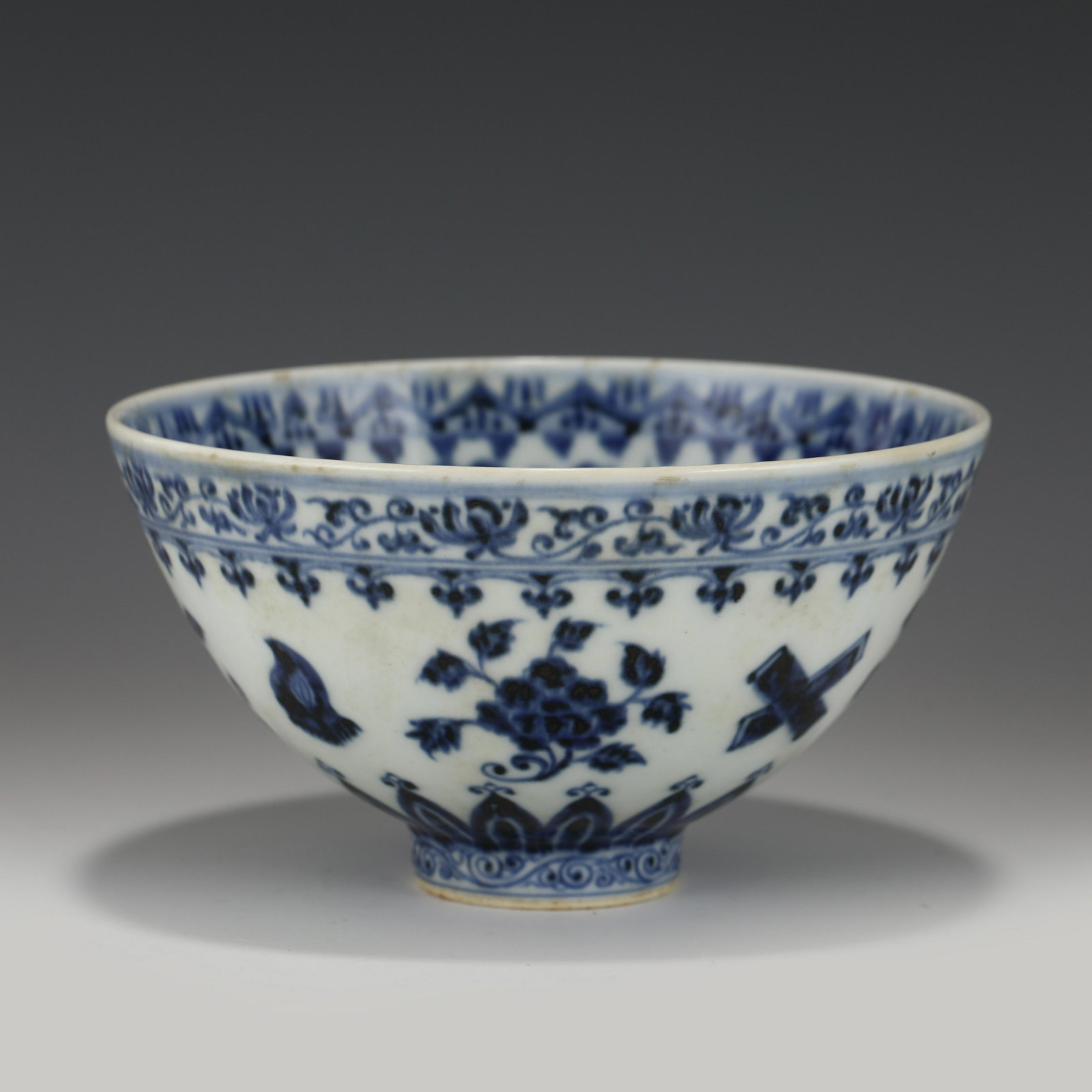 XUANDE BLUE & WHITE FLORI PORCELAIN BOWL: Measurements: Height: 8.7 cm, Diam.: 16 cm Chinese Ming Dynasty XuanDe Blue & White Flori Motif Porcelain Bowl. The bowl has an open mouth, rounded lip rim, thick, deep arced body, raised with round f