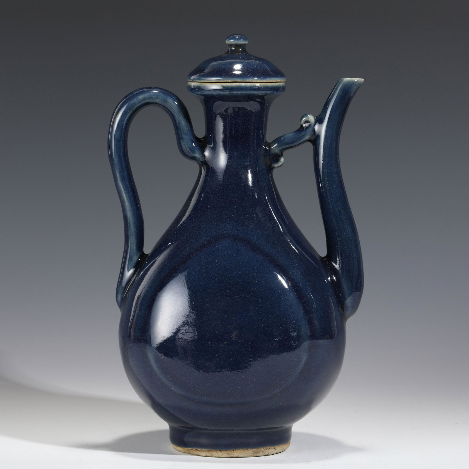 MING DYNASTY BLUE PORCELAIN JUG: Measurements: Height: 27 cm, Diam.: 16 cm Chinese Ming Dynasty Blue Glazed Motif Porcelain Jug. The Porcelain potted in wine pot shape, globular lower body, short cylindrical neck with dome lid finial