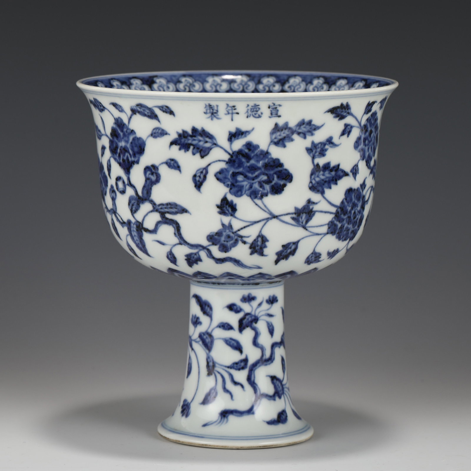 XUANDE BLUE & WHITE FLORI PORCELAIN HIGH FOOT BOWL: Measurements: Height: 17.4 cm, Diam.: 15.5 cm Chinese Ming Dynasty XuanDe Blue & White Flori Motif Porcelain High Foot Bowl. This bowl has a lightly flaring open mouth-rim, round body shaped, deep arc