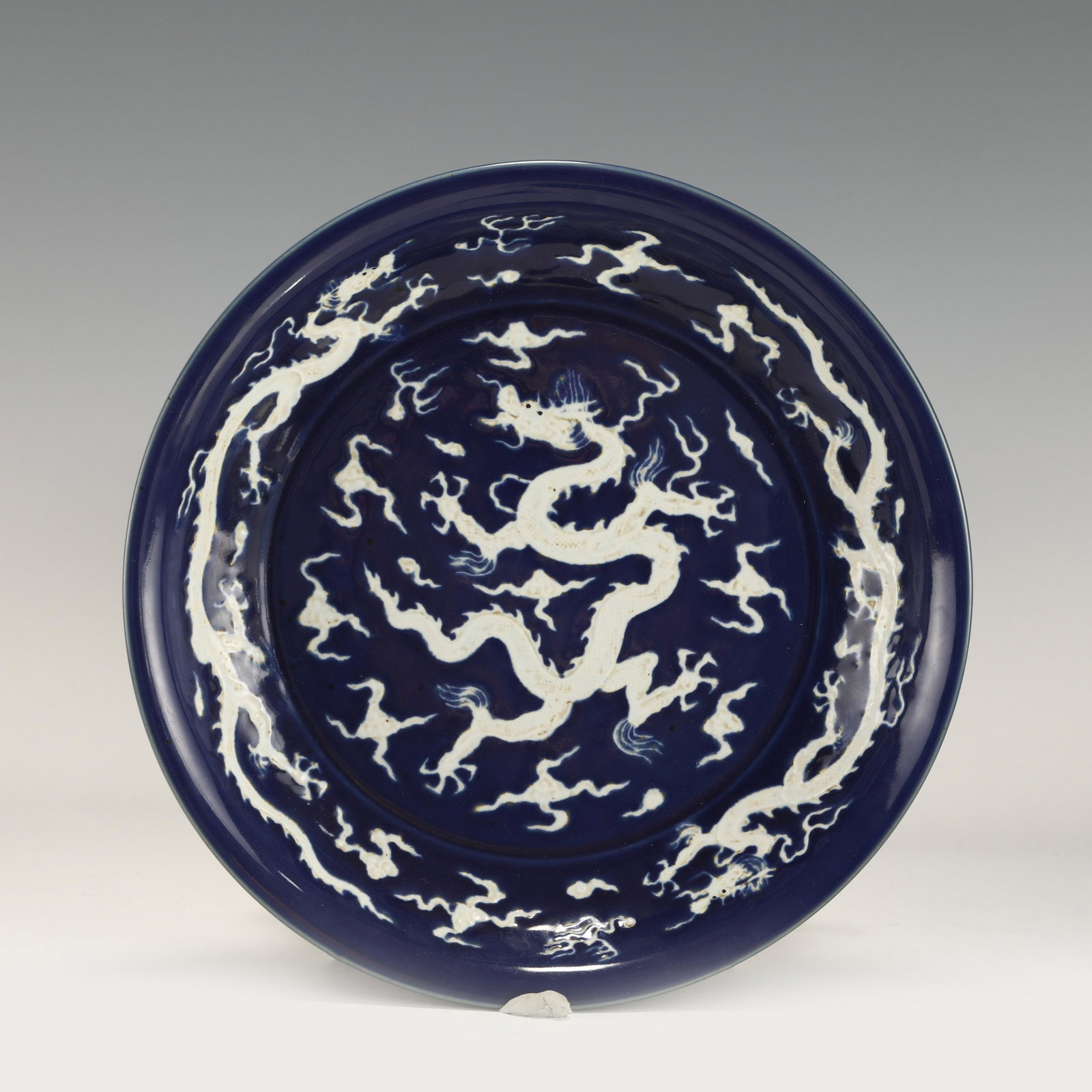 MING REVERSED BLUE AND WHITE DRAGON PLATE: PROVENANCE: From private collectors in Gables Estates, Miami, Florida. Measurements: Height: 6.2 cm, Diam: 40.6cm Chinese Ming Dynasty ReversedJi Blue and White Dragon Porcelain Plate. The plates has 