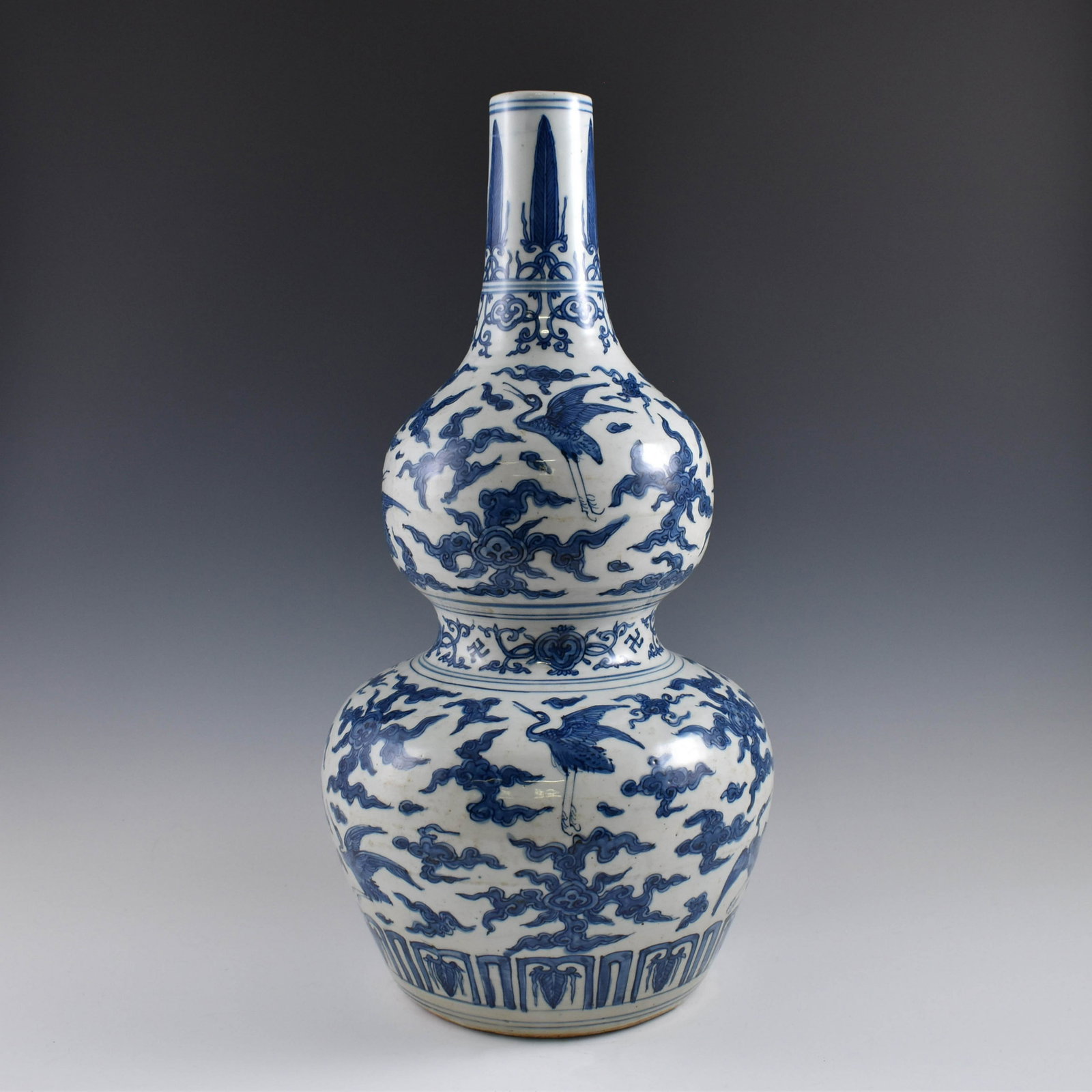 MING BLUE & WHITE CRANES OVER CLOUDS DOUBLE GOURD VASE: Dimensions: 22-3/4" H x 10" Dia. Chinese Ming Dynasty period, Blue & white Cranes over clouds double gourd vase. Potted in a shape of double gourd resemblance, with two bulbous bellies conjoined toget