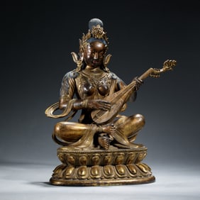 A GILDED BRONZE STATUE OF SARASWATI PLAYING MUSICAL INSTRUMENT