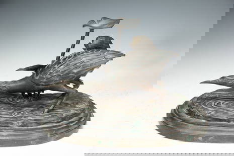 BRONZE HERON ORNAMENT: Measurements: L. 34 cm. W. 23 cm. H. 20 cm. Weight 3820 grams. This is a bronze heron ornament. The heron has a vivid posture, as if foraging or in motion. The feathers on its body are exquisitely car