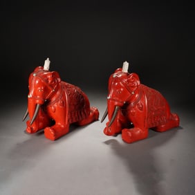 PAIR OF RED - LACQUERED KNEELING ELEPHANT ORNAMENTS