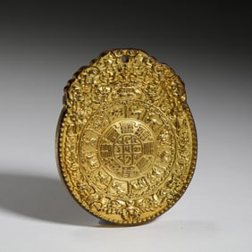 GILT BRONZE AMULET WITH INTRICATE SYMBOLIC CARVINGS