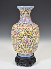 A CHINESE YELLOW-GROUND FAMILLE-ROSE VASE WITH QIANLONG MARK