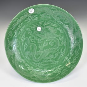A LARGE MOLDED GREEN-GLAZED NINE DRAGONS CHARGER