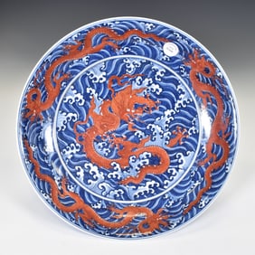 A LARGE UNDERGLAZE-BLUE AND IRON-RED DRAGON AND WAVES CHARGER