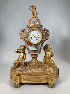 JAPANESE IMARI PORCELAIN AND ORMOLU MOUNTED MANTEL CLOCK, 19TH CENTURY: JAPANESE IMARI PORCELAIN AND ORMOLU MOUNTED MANTEL CLOCK, 19TH CENTURY urn shaped with three ormolu mounted cherubs with Roman Numeral and Arabic dial. Dimensions Height: 22" Width: 16" Depth: 6"